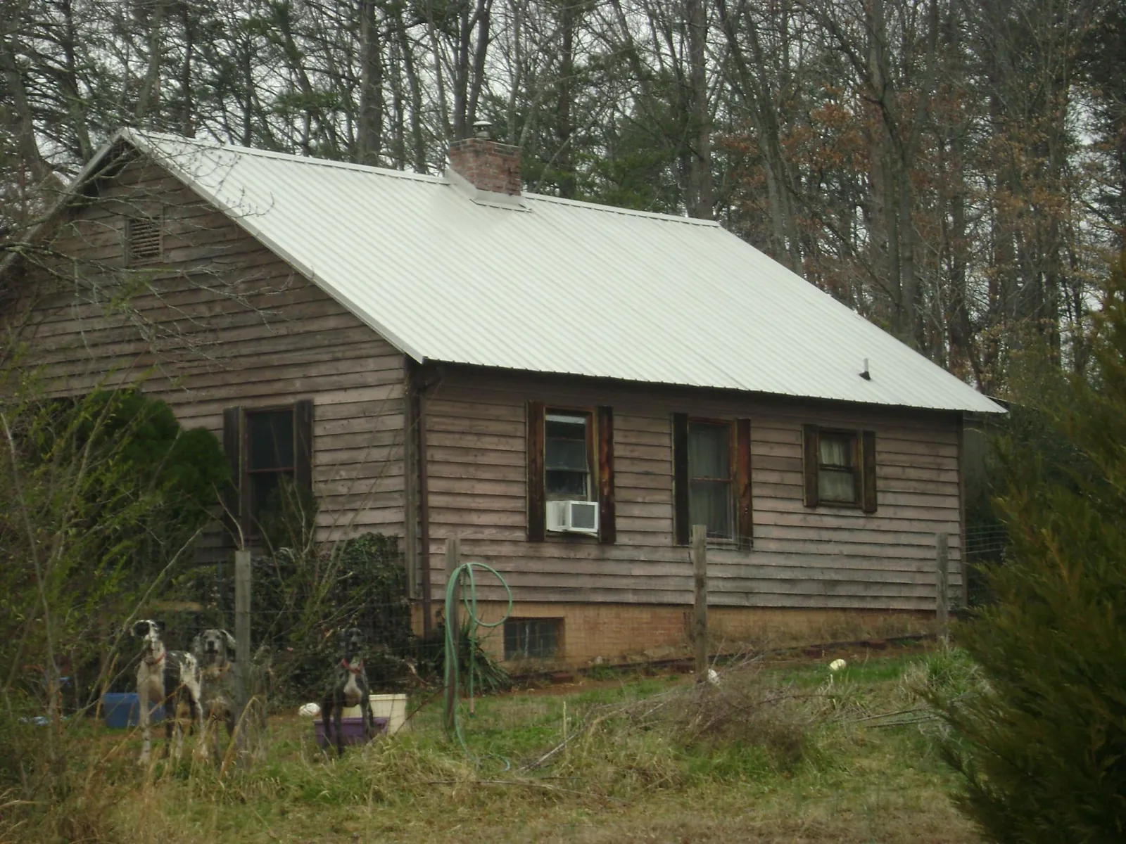 White metal roof on an old wood sided farmhouse, from a Metal Roof Installation job in Fountain