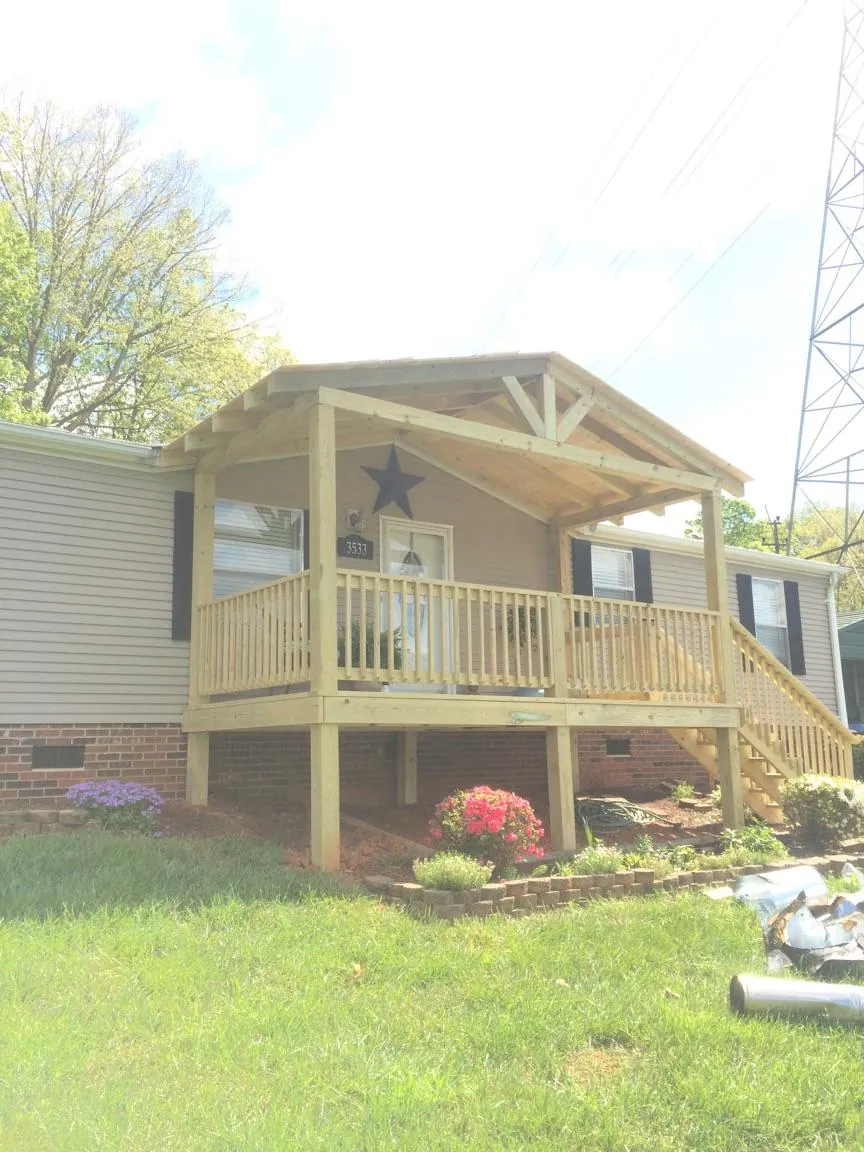 New gabled porch roof and deck railing added to a ranch home in Fountain